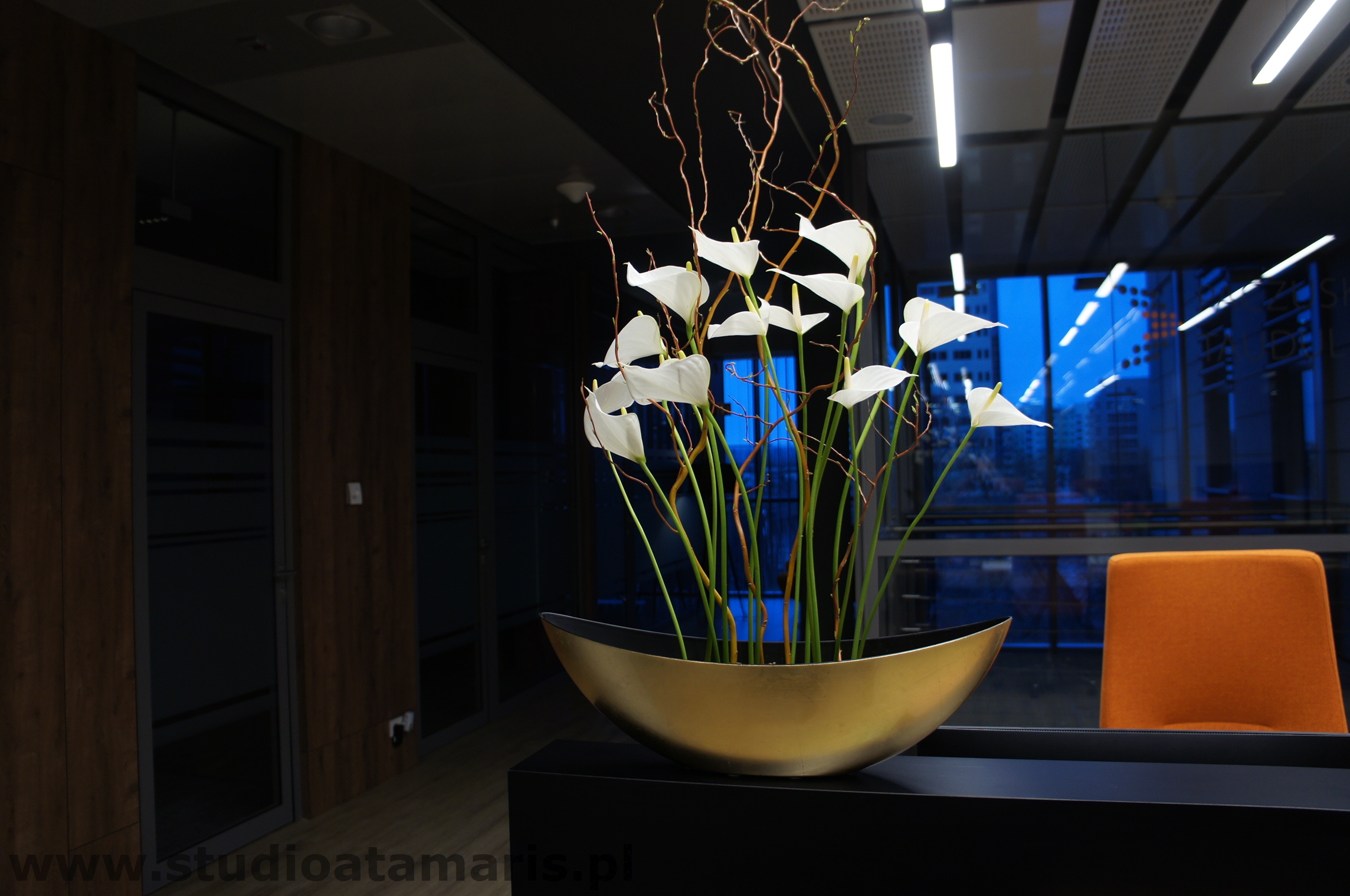 Kwiaty cięte w podłużnym złotym naczyniu